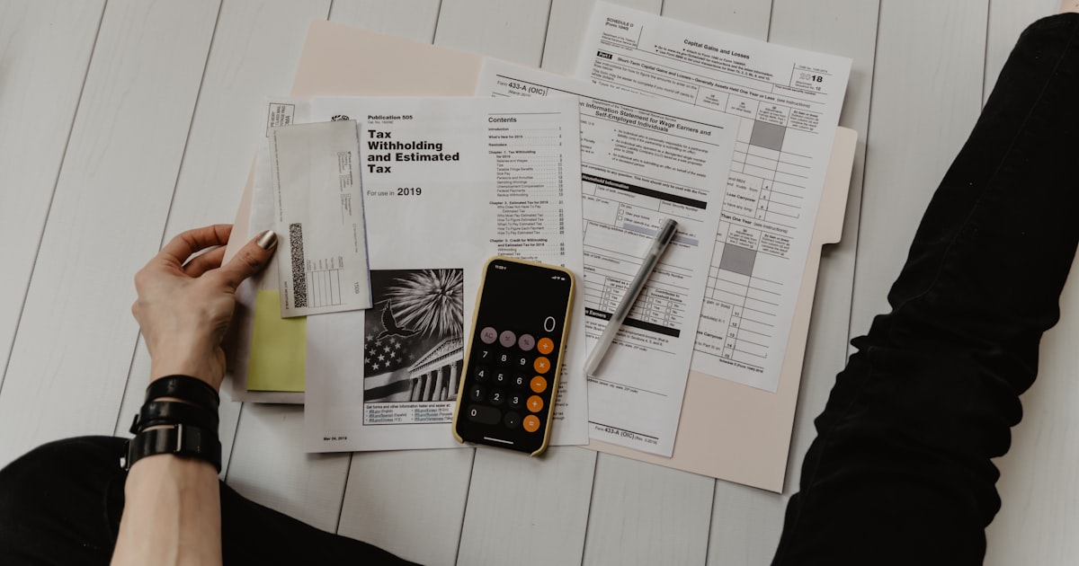 Manos trabajando con documentos y calculadora